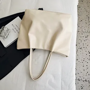 Detailed shot of cream-colored large-capacity tote bag in a stylish lifestyle setting