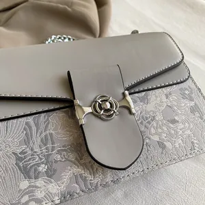 Close-up of vintage small square bag with silver ring buckle and mixed fabric texture