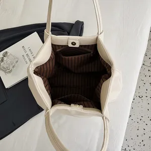 Inside view of cream tote bag showing striped lining, zipper pocket and magnetic closure