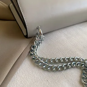 Close-up of gray leather shoulder bag with textured finish and silver chain strap
