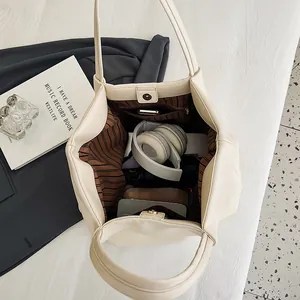 Overhead view showing a large cream tote bag with striped lining and magnetic closure