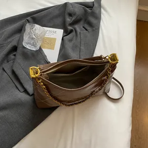 Detail of quilted brown shoulder bag showing internal lining and metallic chain strap