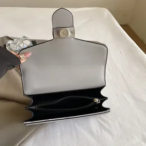 Internal view of the crossbody bag showing multiple compartments and zipper pocket