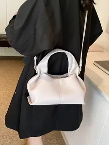 Minimalist beige pebble leather handbag for women featuring a stylish top handle and shoulder strap