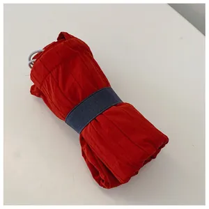 Close-up of portable nylon tote bag in compact rolled state with elastic strap