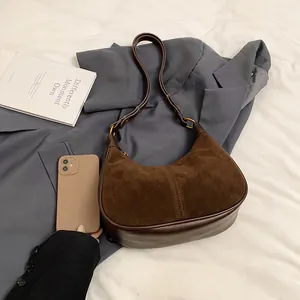 Sac hobo en daim marron avec un smartphone pour montrer la capacité de rangement