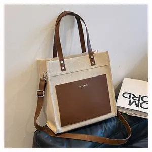 Detail of the canvas tote bag showing the MYCARE pocket and leather shoulder strap buckle