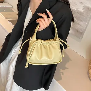 Close-up of cream drawstring pleated cloud bag with soft faux leather texture