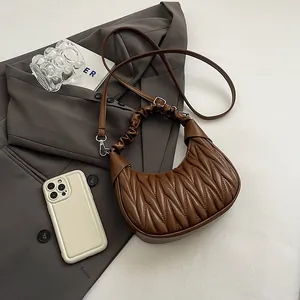 Detail of dark brown pleated matelassé cloud bag with adjustable shoulder strap