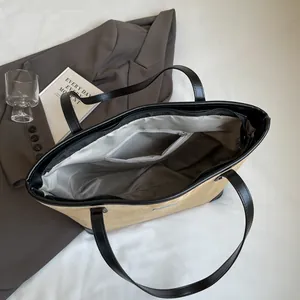 Top view of tote bag showing smooth fabric lining, inner zipper pocket and black handles