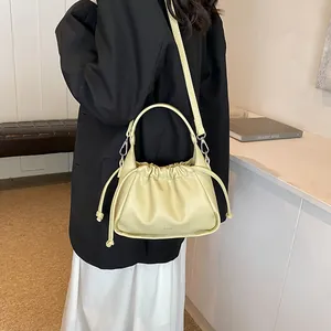Detailed view of the drawstring pleated design on a light green leather cloud bag