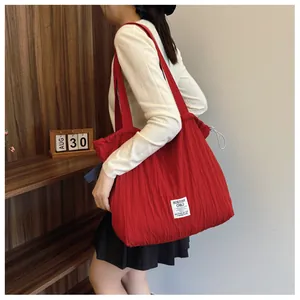 Macro shot of red nylon tote bag with drawstring detail and minimalist logo patch
