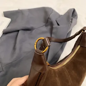 Détails du sac à main en daim marron foncé et cuir avec des ferrures dorées chic