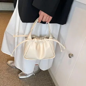 Close-up of cream pleated cloud bag with soft leather texture and drawstring detail