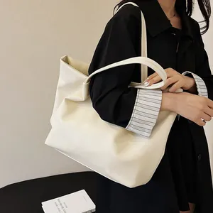 Detail of minimalist beige PU leather tote bag showing large capacity and shoulder strap