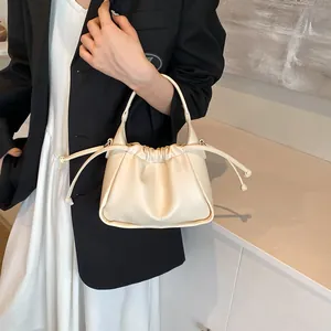 Detail shot of the cream-colored pleated cloud bag with drawstring and soft leather texture