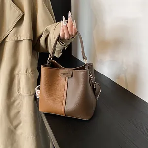 Close-up of the vintage bucket bag in brown lychee pattern leather with embossed logo