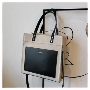 Detailed macro view of the MYCARE contrast color tote bag with black leather front pocket