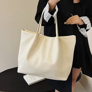 Detail of a minimalist off-white oversized tote bag with soft leather texture for daily use