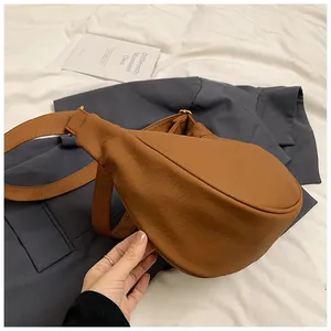 Détails de la sacoche marron à motif litchi avec bandoulière large et boucle dorée