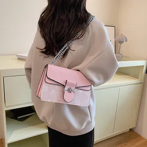 Pink shoulder bag featuring a floral silver clasp and a stylish metal chain strap