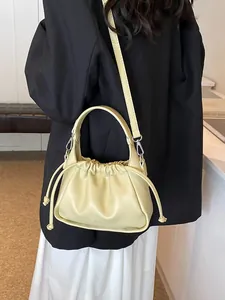 Chic cream-colored drawstring cloud bag with top handle and detachable shoulder strap