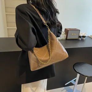 Detail of caramel patent leather shoulder bag with large quilted diamond pattern