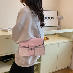 Detail of a pink crossbody bag featuring jacquard stitching and a silver metal chain strap