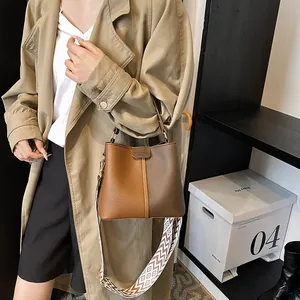 Detail of vintage bucket bag with contrast leather and ethnic pattern shoulder strap