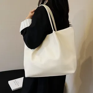Large capacity white tote bag in matte PU leather worn by a model for a commute look