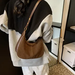 Détail du sac hobo marron foncé montrant la texture du daim et les boucles dorées