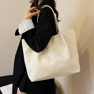Close-up of cream large capacity tote bag showing smooth PU leather texture on shoulder