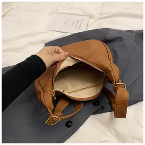 Vue détaillée du sac vintage marron montrant l'intérieur spacieux et la poche zippée