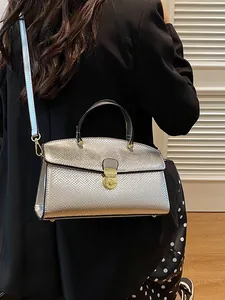 Vintage Handtasche mit Silber-Schlangenmuster und Goldverschluss an einem Modell gezeigt