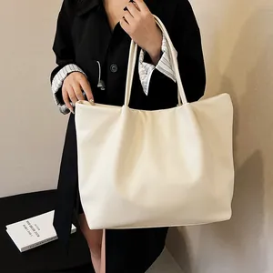 Detail of soft cream faux leather tote bag showing large capacity and smooth texture