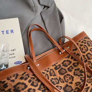 Macro detail of leopard print tote bag with brown leather trim and silver metal hardware