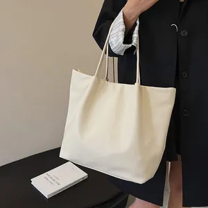 Detail of minimalist cream white large capacity tote bag with soft leather texture