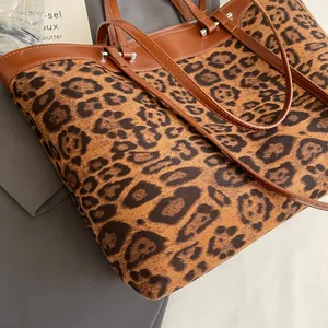 Detail of the leopard print texture and brown leather strap on a large tote bag