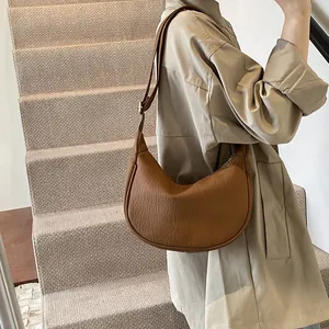 Détail du sac hobo demi-lune marron avec texture cuir plissé et bandoulière réglable