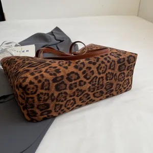 Close-up of leopard print tote bag with soft suede texture and brown leather straps