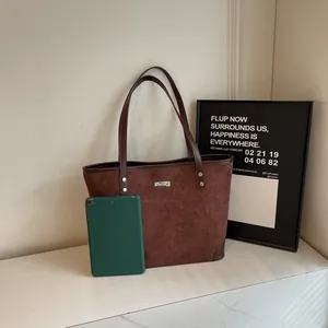 Detail view of a brown suede tote bag showing large capacity for a green tablet
