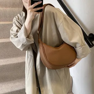 Sac hobo marron caramel chic porté avec un trench beige pour un look automnal élégant