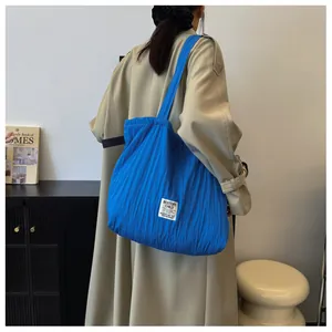 Detail of royal blue pleated nylon tote bag showing rich texture and large capacity