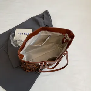 Interior details of leopard print tote bag showing zipper pocket and spacious lining