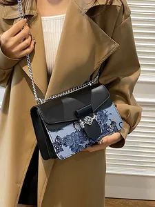 Chic color-block crossbody bag with floral pattern and silver chain strap on model