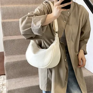 Vue détaillée d'un sac demi-lune blanc avec texture en cuir souple plissé