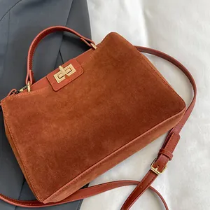 Détail du sac cabas en daim marron caramel avec fermoir doré et poignée haute