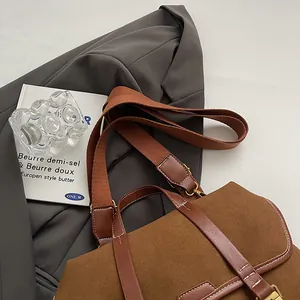Detail of vintage brown matte tote with contrast white stitching and gold hardware