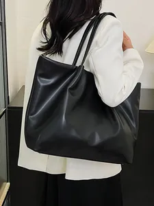 Large black leather tote bag for women, minimalist shoulder bag styled with a white blazer