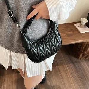 Detail of black quilted cloud bag showing pleated leather texture and silver hardware